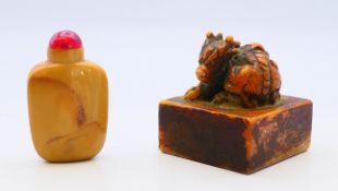 A Chinese seal and a Chinese hardstone snuff bottle and stopper. Each 6 cm high.