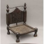 An Indian antique low hardwood chair with reeded seating. 64 cm high.