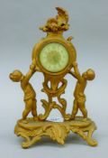 A Victorian gilt mantle clock and a cast iron portrait roundel. The former 24 cm high.