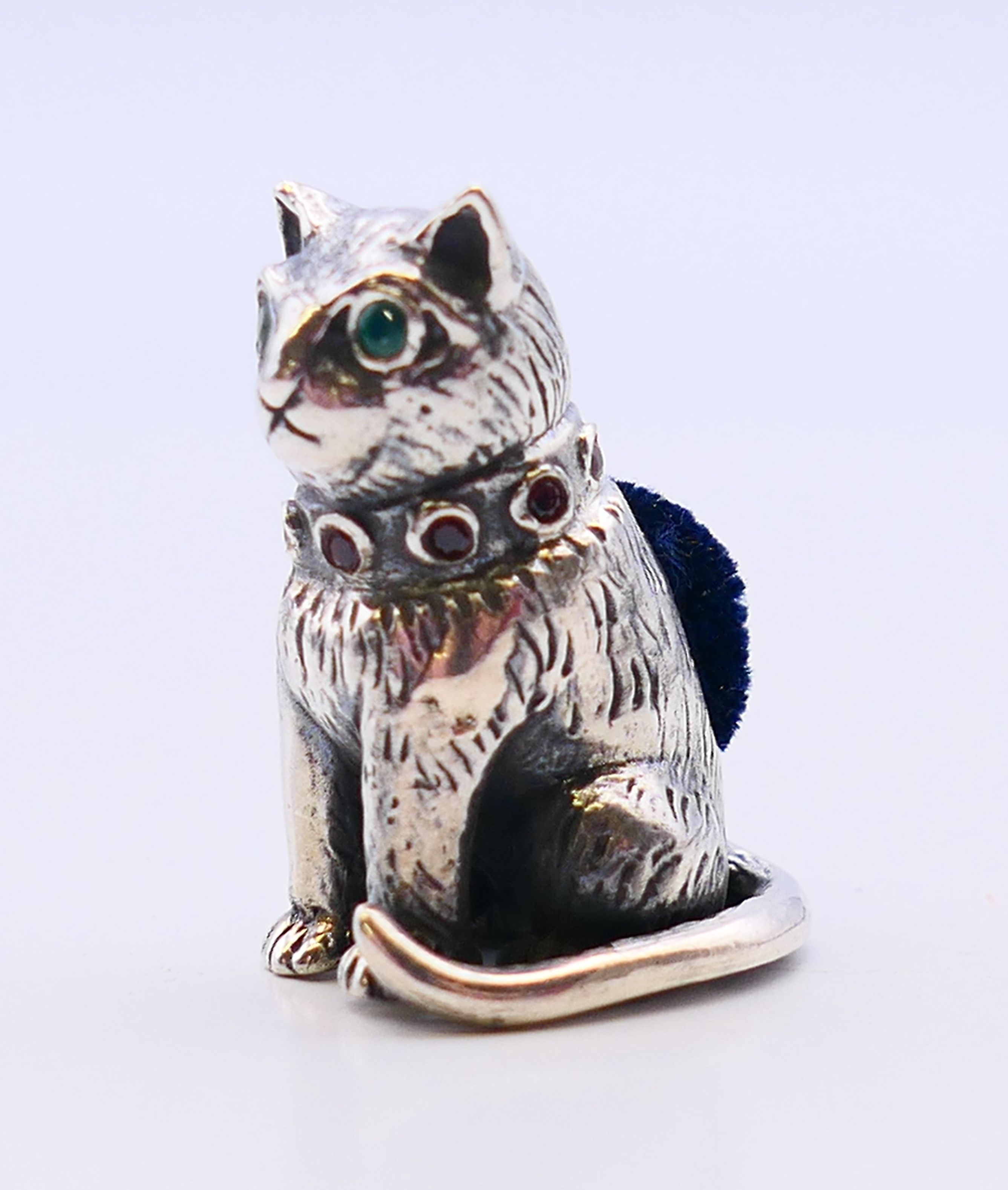 A silver pin cushion formed as a cat. 2.5 cm high.