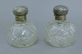 A pair silver-topped cut glass scent bottles. 11 cm high.