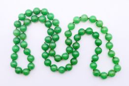 A string of apple green jade beads. 82 cm long.
