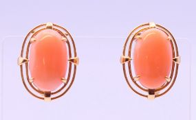 A pair of unmarked gold coral clip-on earrings. 2 cm high.