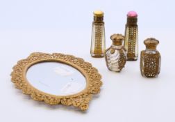 A collection of four Victorian miniature perfume bottles with pierced brass overlay together with a