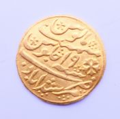 An Eastern high carat gold coin. 2.7 cm diameter. 12.7 grammes.