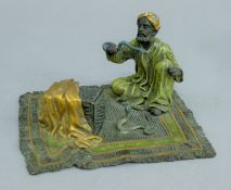 A cold-painted bronze model of a snake charmer 13.5 cm wide.