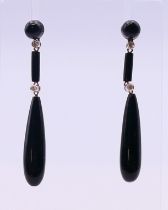 A pair of platinum and diamond onyx earrings. 5 cm high.