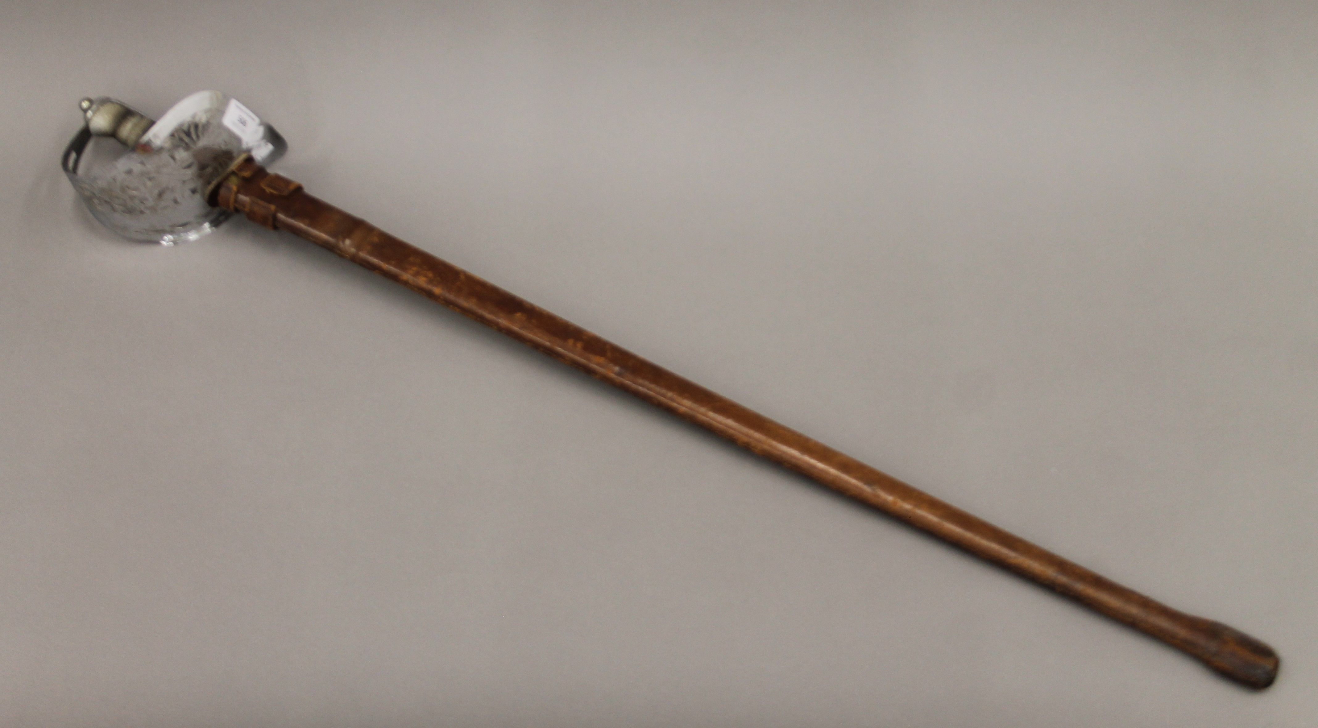 A George V service sword in leather scabbard. 102 cm long.