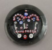 A 19th century glass paperweight with canes forming a crown. 8 cm diameter.