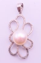 A 14 K white gold, pearl and diamond pendant. 3.5 cm high.