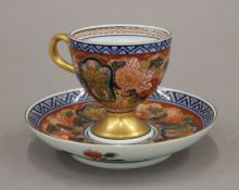 A Japanese signed Imari cup and saucer. The latter 14.5 cm diameter.