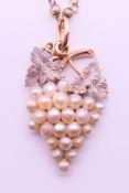 A gold and pearl pendant necklace, the pendant formed as a bunch of grapes. 50 cm long.