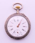 A silver pocket watch. 4 cm diameter.