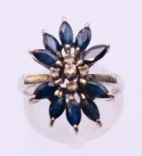 An 18 K white gold, diamond and sapphire flowerhead ring. Ring size M/N.