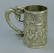 A Chinese silver embossed tankard with dragon-form handle. 11.5 cm high. 7.9 troy ounces.