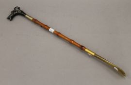 A shoe horn with dog's head handle. 54.5 cm long.