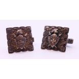 A pair of silver cufflinks with an embossed shield. 2 cm x 2 cm. 16.4 grammes.