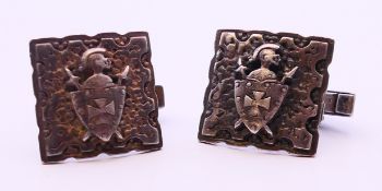 A pair of silver cufflinks with an embossed shield. 2 cm x 2 cm. 16.4 grammes.