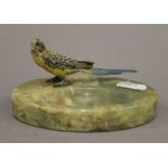 A cold-painted bronze budgie mounted on an onyx ashtray. 12 cm long overall.