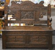 A Victorian carved oak settle. 106 cm wide.