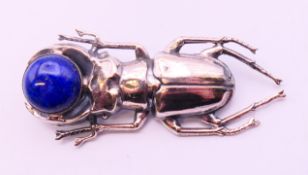 A silver and lapiz scarab brooch. 6 cm long.