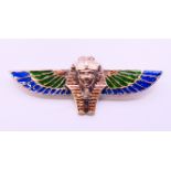 A silver enamel winged Pharaoh brooch. 8 cm long.