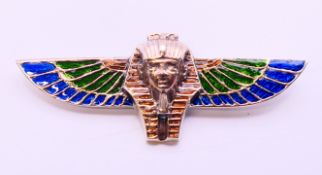 A silver enamel winged Pharaoh brooch. 8 cm long.
