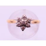 An unmarked gold and diamond set daisy head ring. Ring size L.