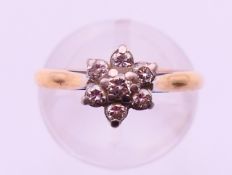 An unmarked gold and diamond set daisy head ring. Ring size L.