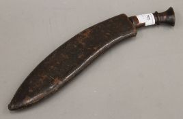 An early 20th century kukri knife with leather-covered wooden scabbard. 40 cm long.