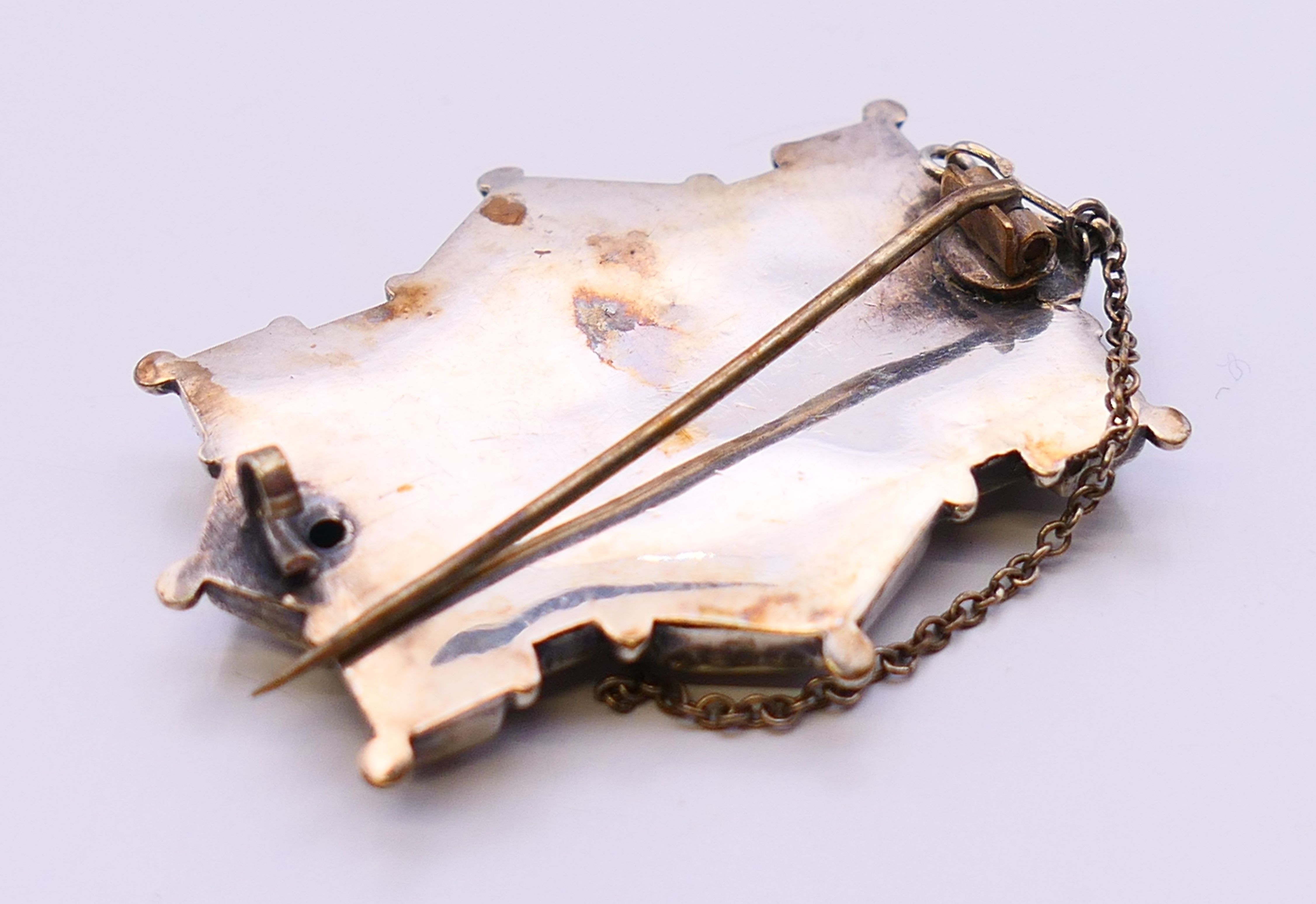 A Victorian silver brooch, a posy holder brooch and a silver and jade tiger tooth shaped pendant. - Image 4 of 8