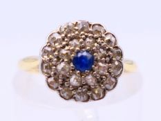 A gold, sapphire and diamond flowerhead ring. Ring size J.