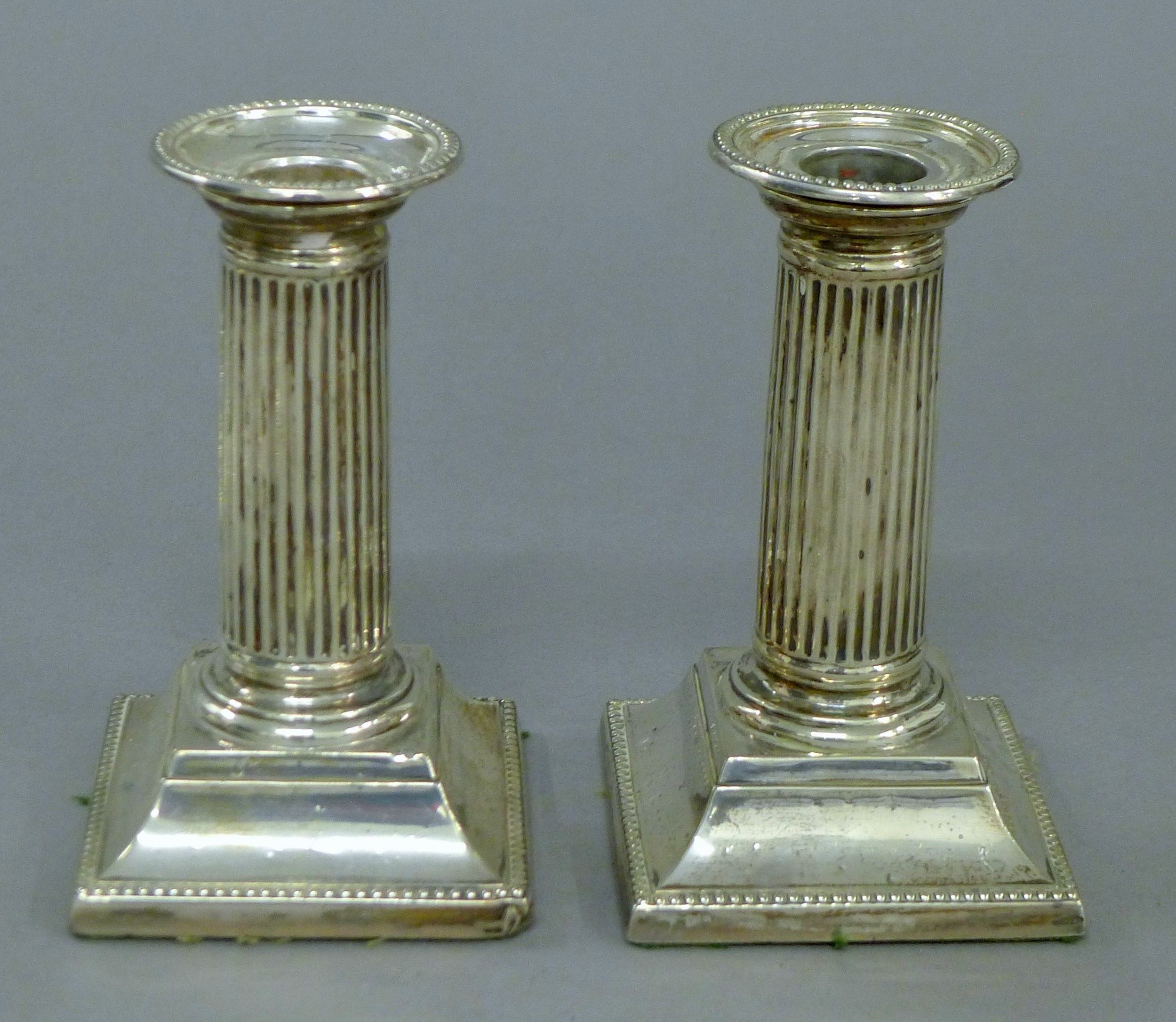 A pair of silver candlesticks. 12.5 cm high.