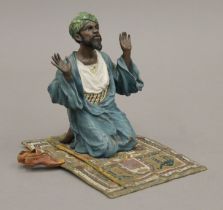 A cold painted-bronze model of a Arab gentleman at prayer. 12 cm high.
