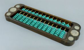 A Chinese coin and turquoise-set wooden abacus. 42 cm long.