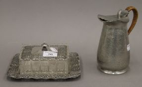 A silver plate mounted butter dish and an Arts and Crafts pewter jug. The latter 17 cm high.