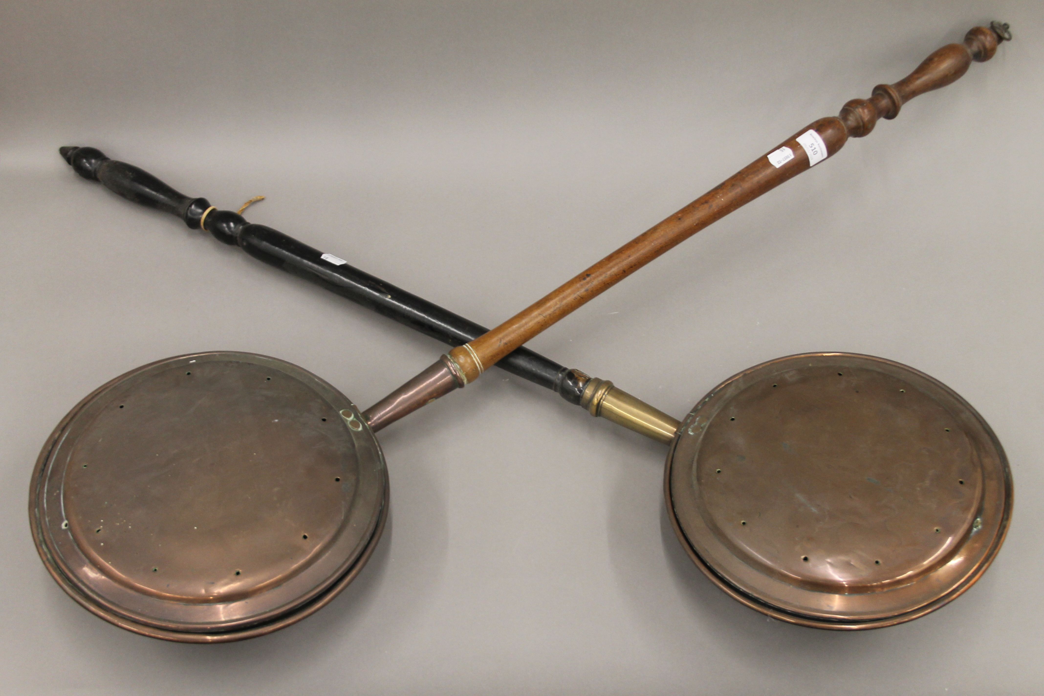 Two Victorian copper warming pans. The largest 115 cm long.