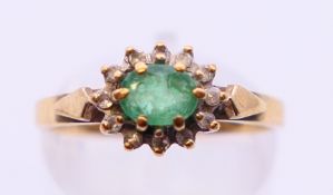 A 9 ct gold diamond and emerald ring. Ring size M.