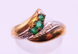 A 9 ct gold diamond and emerald ring. Ring size O.