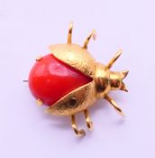 An 18 ct gold and coral ladybird brooch. 2 cm x 2 cm.