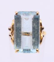 An unmarked gold rectangular aquamarine single stone ring. Aquamarine 2 cm x 1.25 cm.