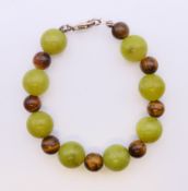 A silver jade and tiger's eye bracelet. 18 cm long.