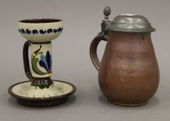 A stoneware stein and a chamber stick. The later 13 cm high.