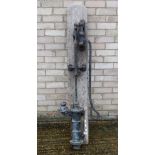 A vintage cast iron pump mounted on a wooden board. 152 cm high overall.