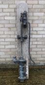 A vintage cast iron pump mounted on a wooden board. 152 cm high overall.