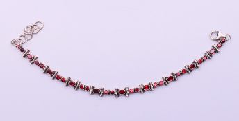 A silver and garnet bracelet. 22 cm long (maximum).