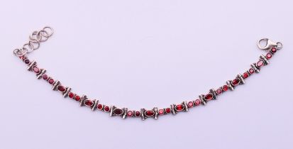 A silver and garnet bracelet. 22 cm long (maximum).