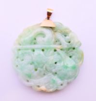 A gold top jade pendant. 5 cm diameter.