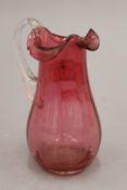 A cranberry glass jug. 13 cm high.