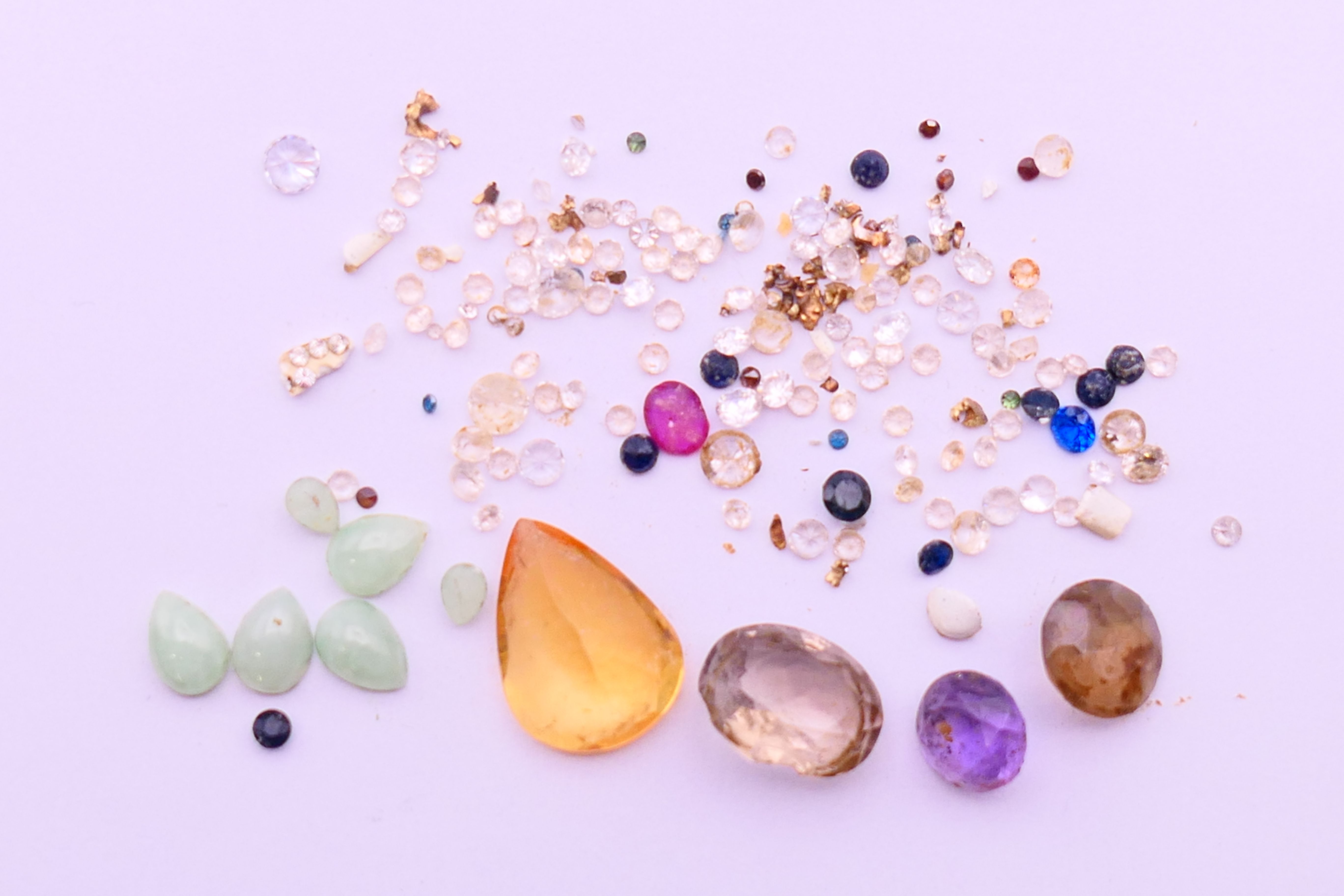 A collection of gemstones, includes diamonds, sapphires, ruby, etc.